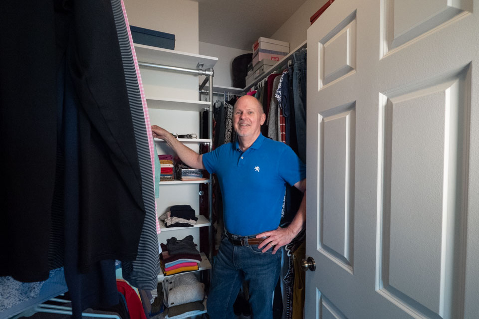 Person standing in front of their DIY closet clothing rack